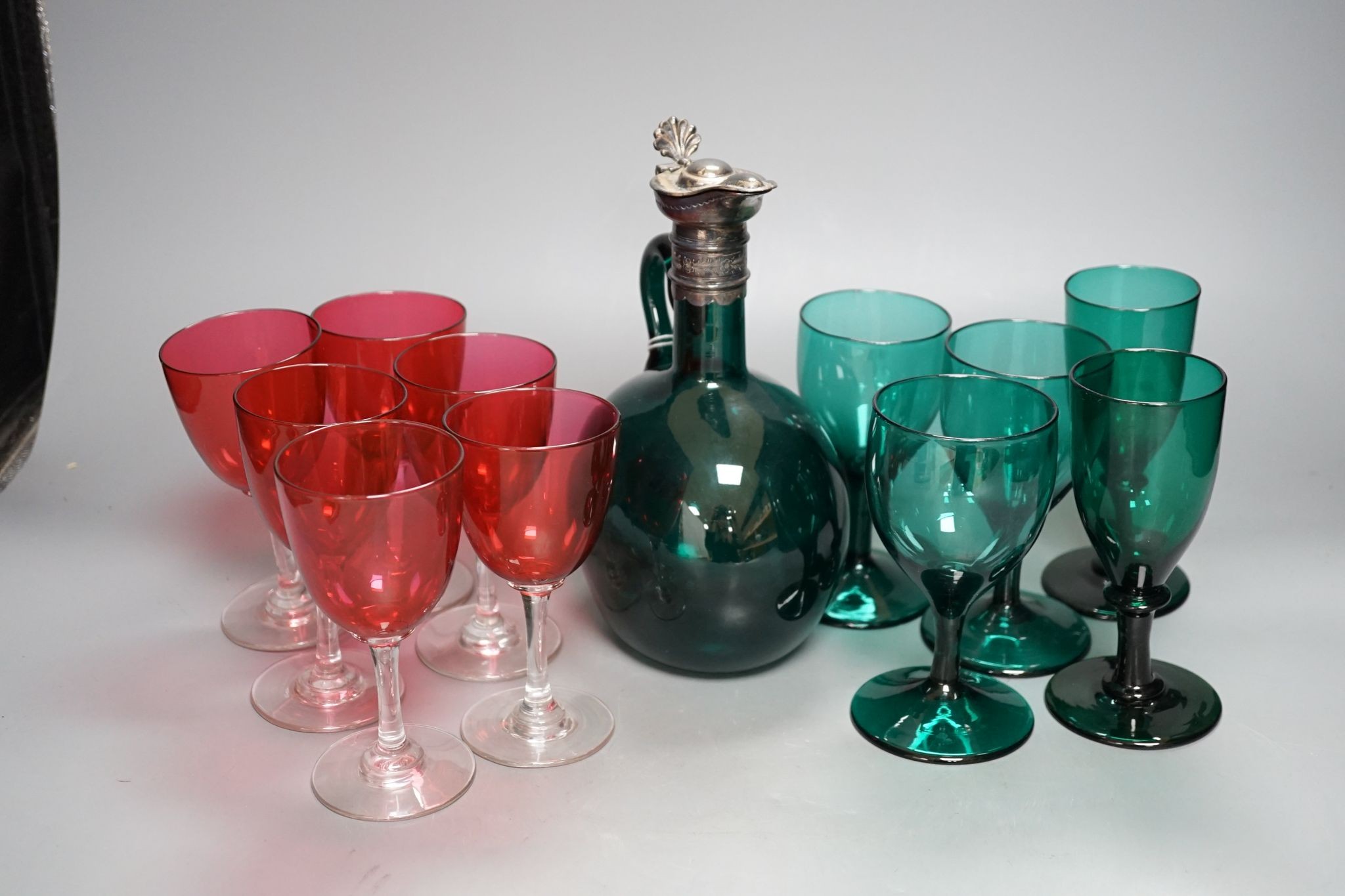A Victorian dark green glass hock jug, five dark green wine glasses and 6 cranberry bowled wine glasses (12)
